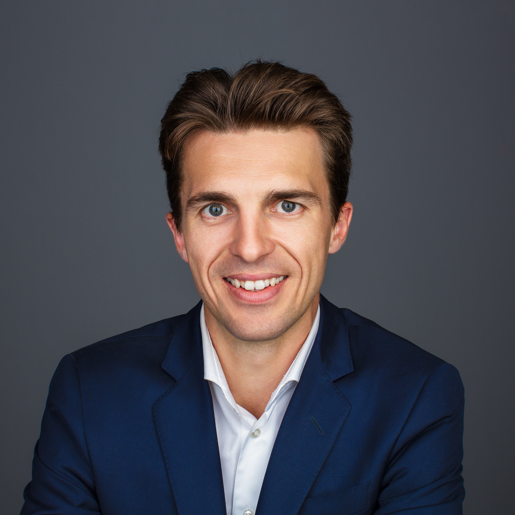 Portrait corpo de Mr Marcotte en veston bleu sur fond gris.
Professional business portrait or Mr Marcotte on a grey background.